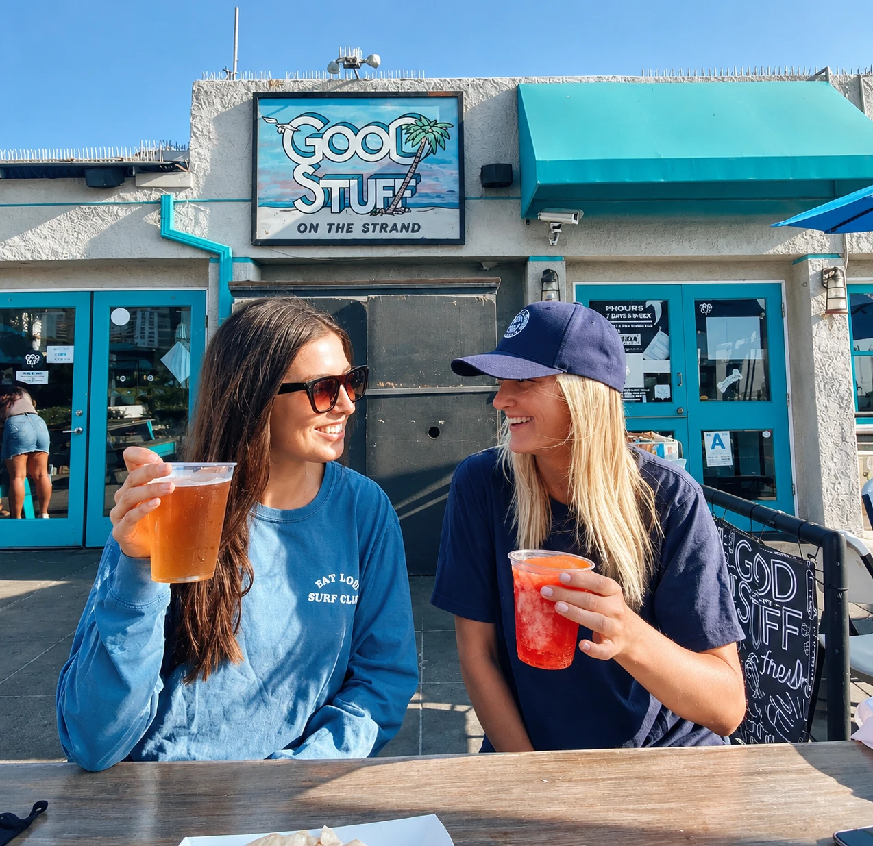 Two friends enjoying drinks on the Good Stuff patio in Hermosa Beach